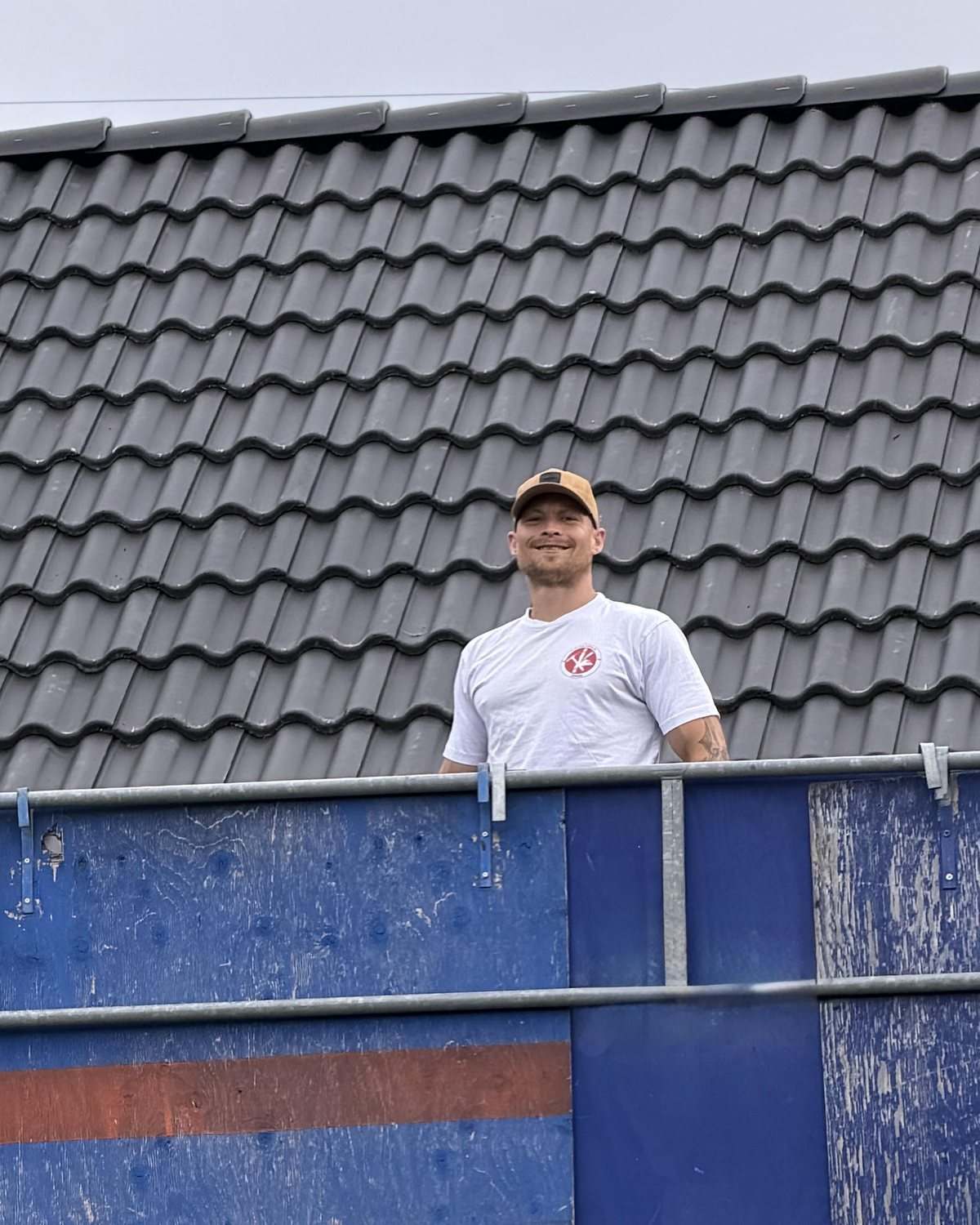 Kristian Næsager på stilladset foran et nyt tag med grå tagsten